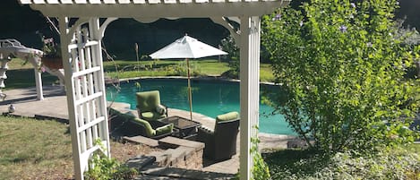 Piscine extérieure en saison, parasols, chaises longues