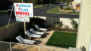 Une enseigne de motel avec des chaises longues à l’extérieur.
