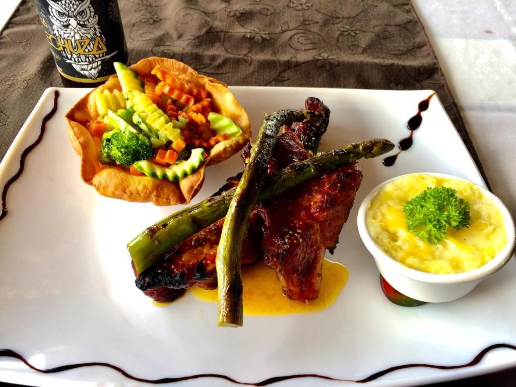Ein Teller mit gegrilltem Fleisch, Spargel und Kartoffelpüree.