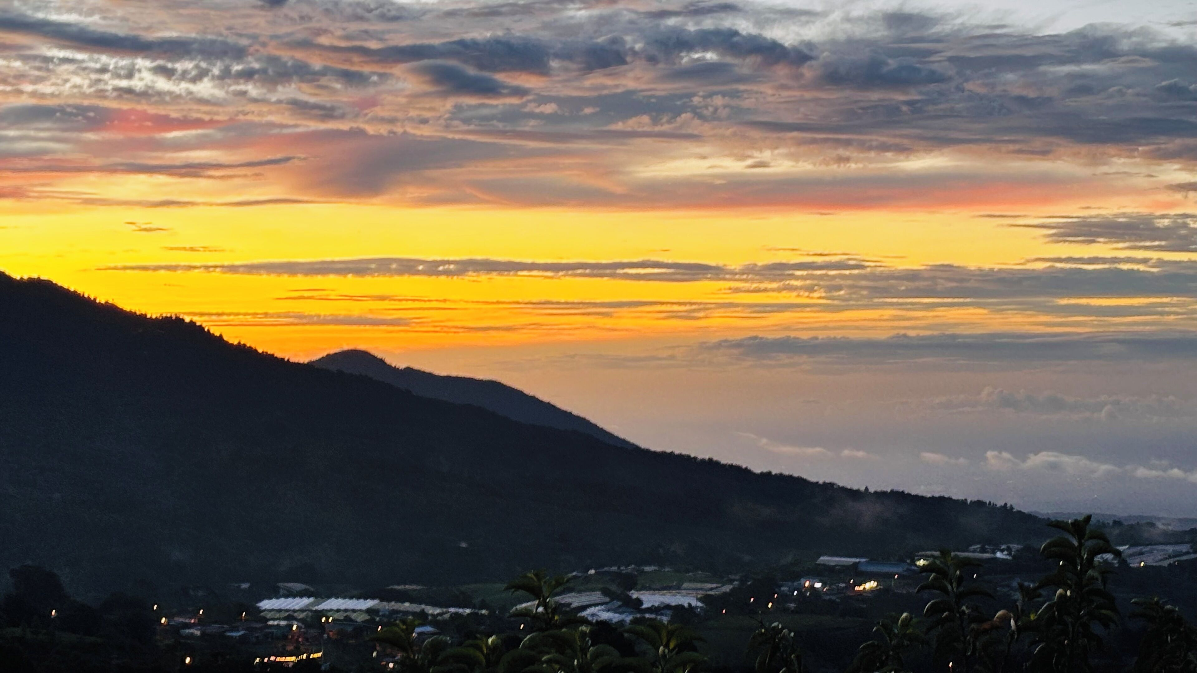 Un paisaje montañoso con un atardecer.