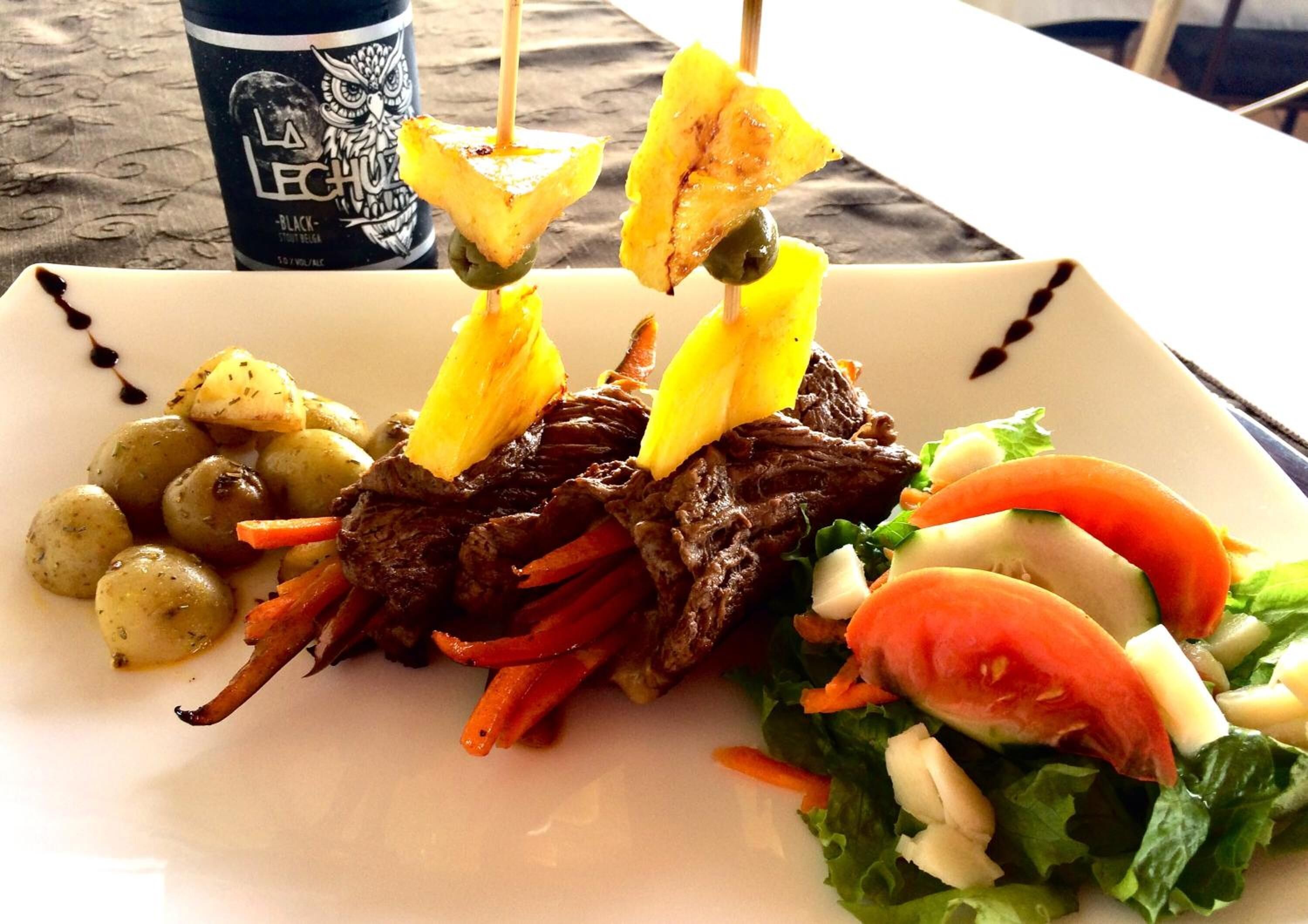Un plato de comida con una bebida al fondo.