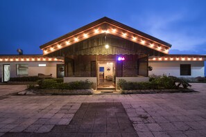 A building with a stone facade, a wooden entrance, and a neon sign. - Hortensias Chalets Vara Blanca (Vara Blanca)