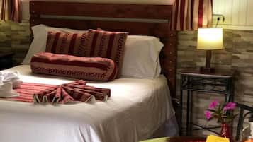 Une chambre à coucher avec un lit, une table de chevet avec une lampe, une chaise et une fenêtre avec des rideaux.