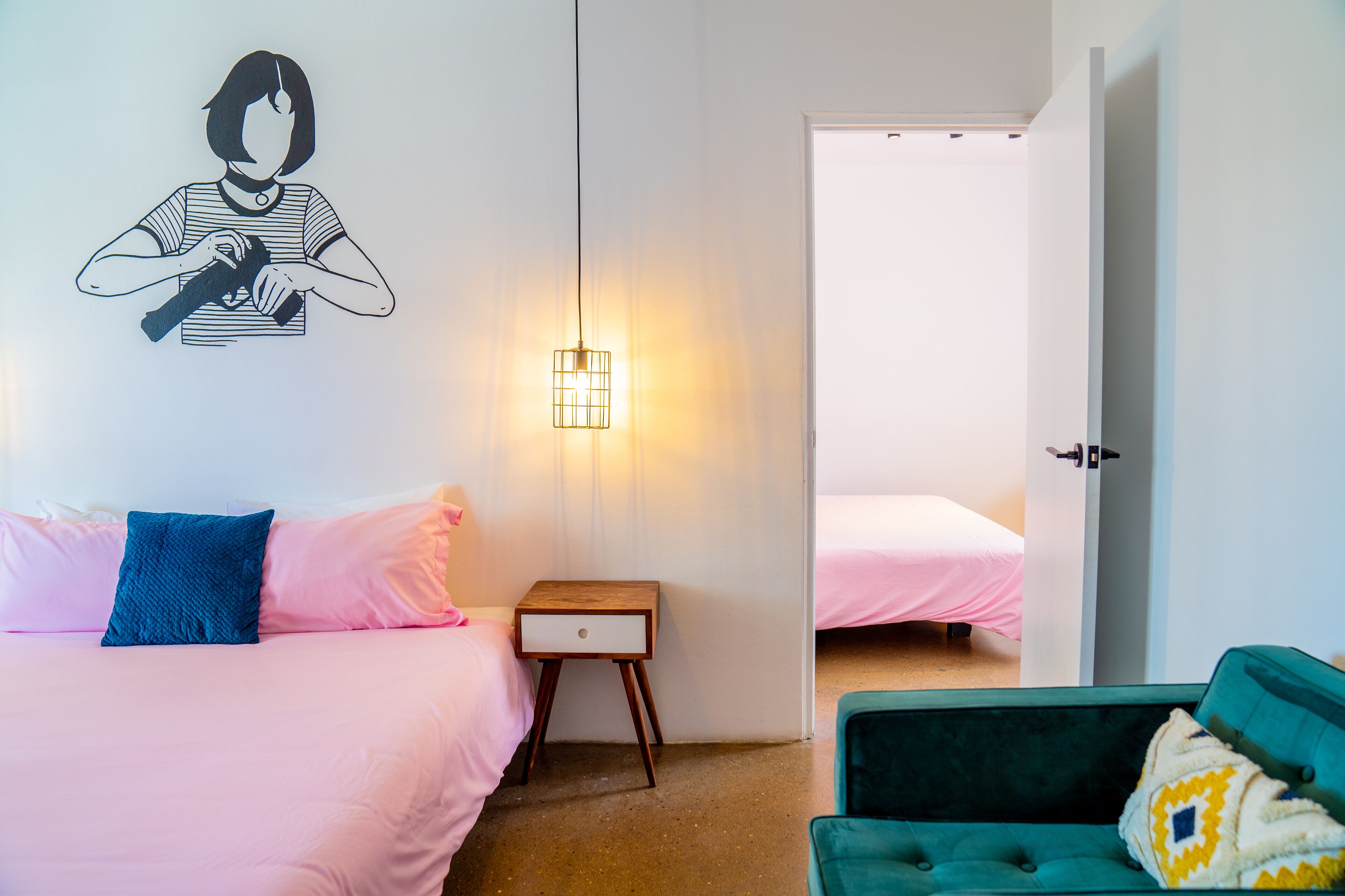 Ein Schlafzimmer mit einem Bett, einem Nachttisch, einer Lampe, einem Sessel und einer Tür zu einem anderen Raum.