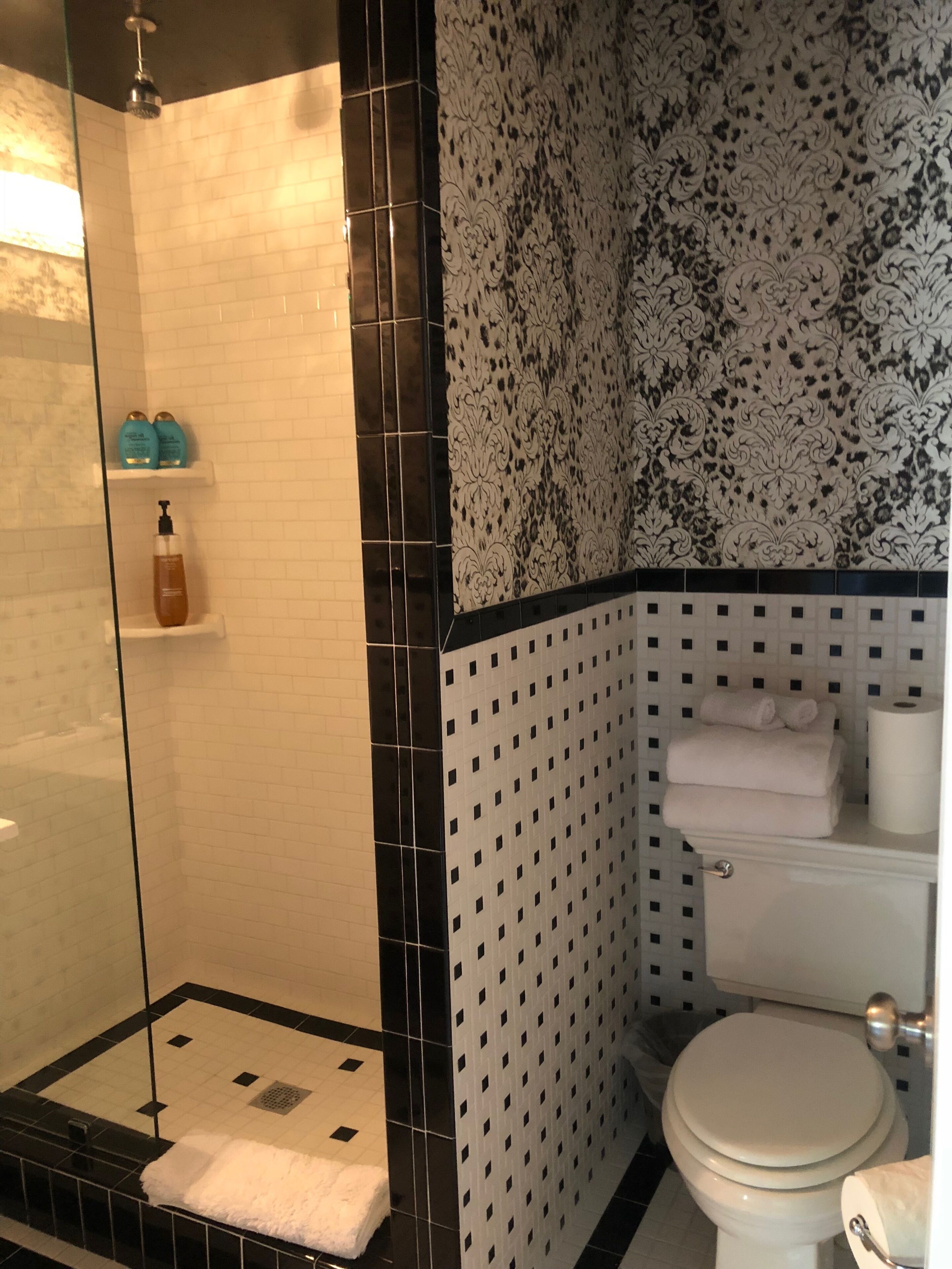 Une salle de bain avec douche, toilettes et lavabo.