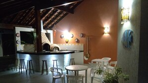 Una cocina con barra, taburetes y una planta en maceta.
