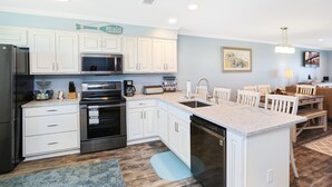 A modern kitchen with white cabinets, stainless steel appliances, and a central island.