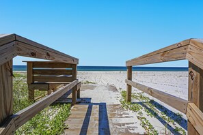 A wooden beach walkway leading to the ocean.