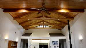 A spacious interior with a high wooden ceiling, a ceiling fan, and a view through a skylight. - Absolute  luxury, surprising additions, welcome hamper & wine, cheese & biscuits (Hunter Valley)