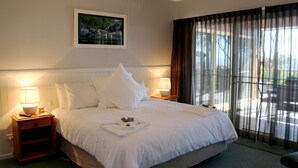 A neatly made bed with white linens, two bedside lamps, a framed photograph on the wall, and a large window with sheer curtains. - Absolute  luxury, surprising additions, welcome hamper & wine, cheese & biscuits (Hunter Valley)