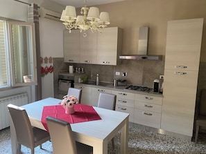 A modern kitchen with a dining area, featuring a chandelier, stainless steel appliances, and light-colored cabinetry. - A VALE OF HOUSE - for rural holiday accommodation (Pistoia)