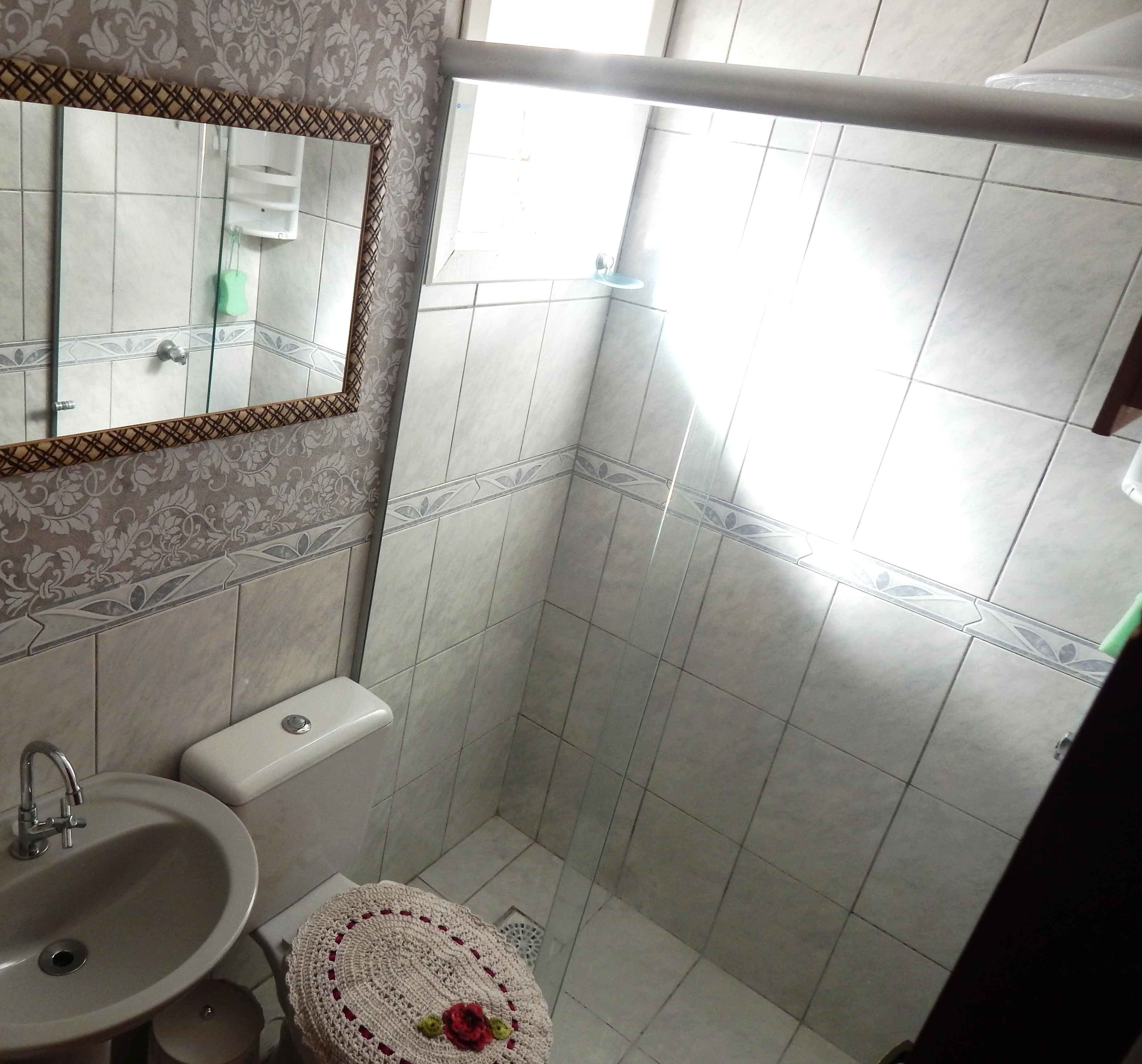 A bathroom with a sink, toilet, and shower area.