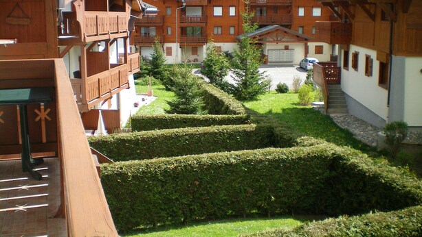Il s’agit d’un bâtiment de style chalet traditionnel, doté de nombreux balcons, d’un jardin bien entretenu avec des haies et offrant une vue sur une vallée verdoyante.
