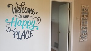 A room with a wall sign that reads "Welcome to our Happy Place."