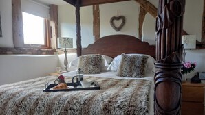 A four-poster bed with a fluffy blanket, a tray with croissants and coffee, and a heart-shaped decoration on the wall. - Luxury Barn nr. Gastro-pub & Lake. Ideal Base for Hay, Ludlow, Hereford.Sleeps 4 (Titley, nr. Kington)