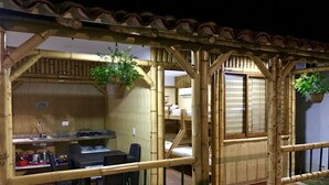 A bamboo-themed room with a dining area, a small kitchen, and a window. - Apartamentos Martinez (San Andrés)