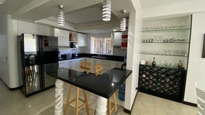 A modern kitchen with a central island, stainless steel appliances, and a wine rack. - Apartamentos Martinez (San Andrés)