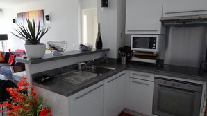 Una cocina moderna con lavavajillas integrado, microondas y horno de acero inoxidable.