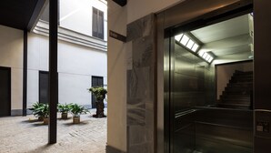 A modern interior with a staircase, potted plants, and a tiled floor. - Corral del Rey Terraza Sevilla Duplex, chillout terrace (Sevilla)