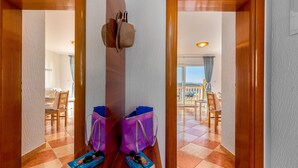 A hallway with wooden doors leading to a dining area and a balcony.