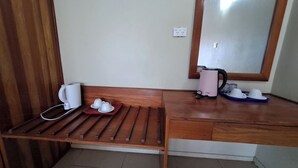 A small kitchenette with a wooden bench, a kettle, and a tray with cups. - Fun World Plaza Hotel (Nadi)