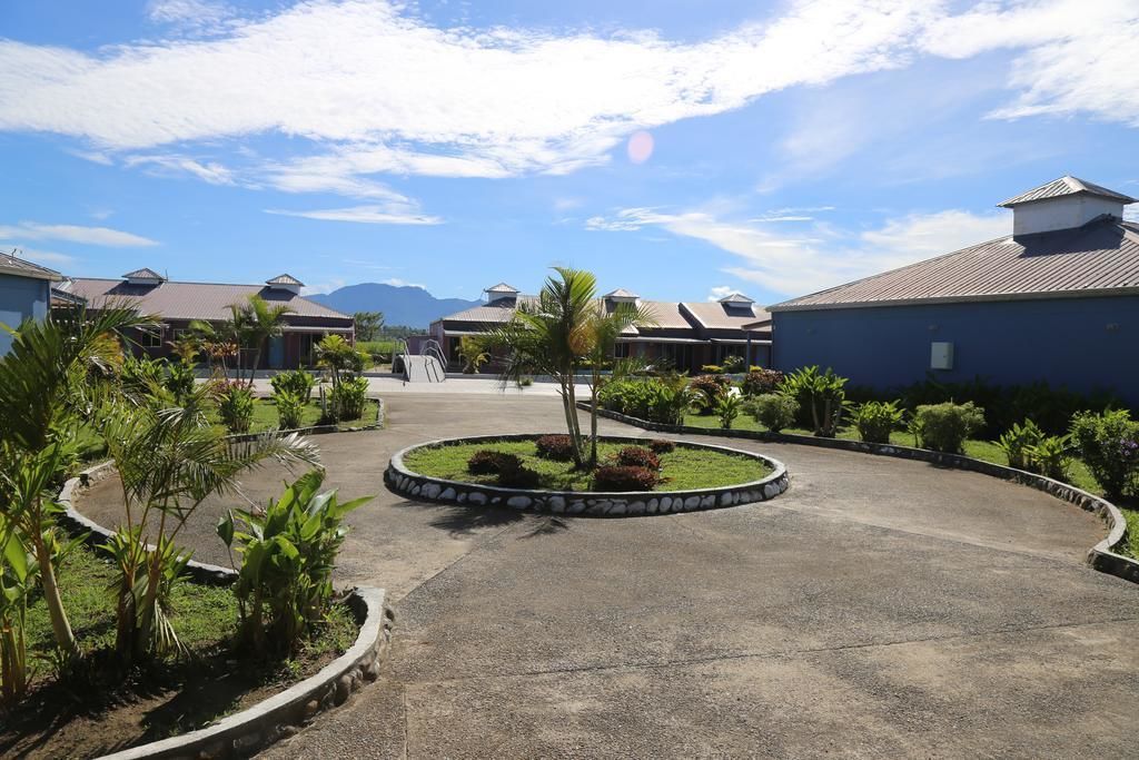 A hotel courtyard with a central circular garden, surrounded by buildings with sloped roofs.