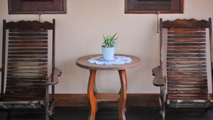Two wooden chairs with a small table and a potted plant between them. - Bannraiphontawan (Nong Khai)