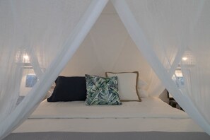 A bed with white bedding, two pillows (one with a leaf pattern), and a canopy. - mist at Cape Tribulation (Cape Tribulation)