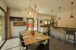 A modern kitchen with a dining area, a bar, and a large window. - Villa Malona des Albères in Sorède 7 km from the beaches (Sorède)