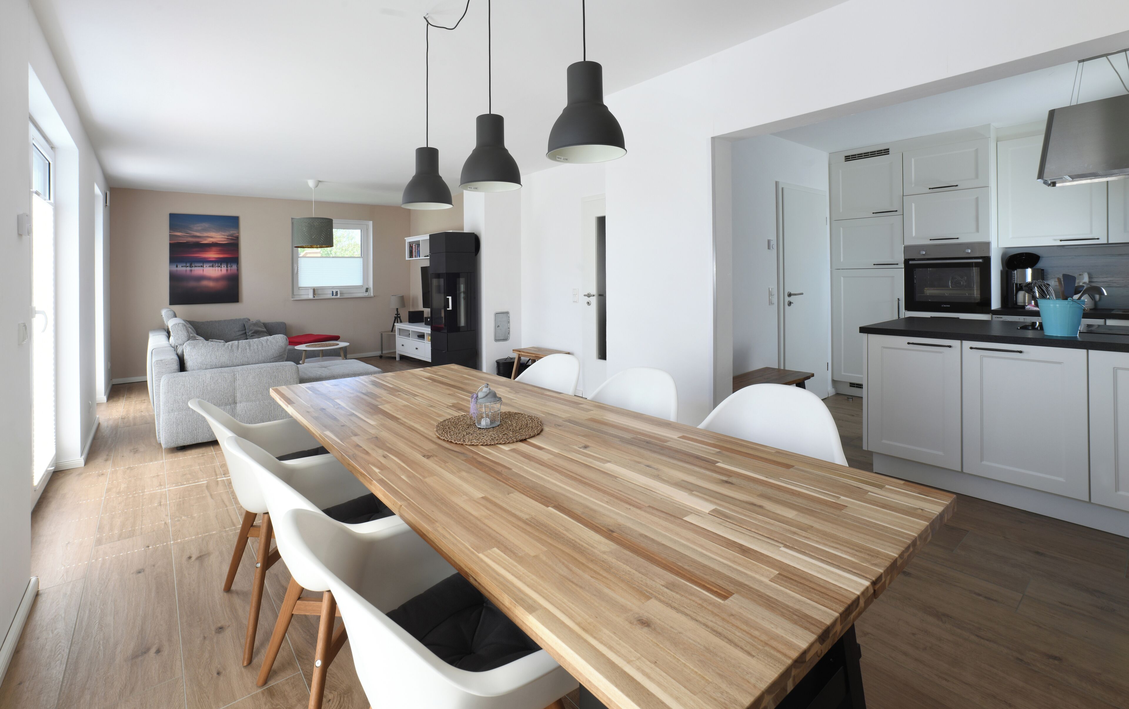 A modern kitchen with white cabinets, a black microwave, and a blue kitchen towel.