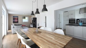 A modern kitchen with white cabinets, a black microwave, and a blue kitchen towel. - NEW 2018 holiday home exclusively near the beach, sauna, fireplace, free WiFi, garden (Wiek /Rügen)