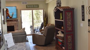 A living room with a fireplace, a TV, and a dog.