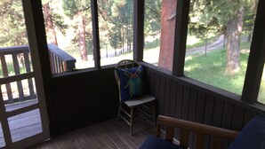 A wooden deck with a chair and a bench, overlooking a forested area. - SWAN VALLEY BUNKBED EFFICIENCY IN CONDON (Condon)