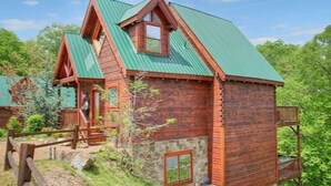 Une cabane rustique avec un toit à forte pente, un revêtement extérieur en bois et des fondations en pierre.