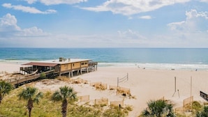 A beachside building with a wooden deck and a view of the ocean.