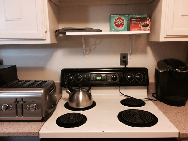 A kitchen with a stove, a toaster, and a coffee maker. - Location, Convenience and Charm by Capitol Hill FREE Parking Included (Washington)