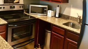 A kitchen with wooden cabinets, a stainless steel stove, a microwave, and a refrigerator. - Casita Del sol, 1 BR 1BA-Sleeps 2. Minimum Stay 4 nights. Great North Phoenix (Phoenix)
