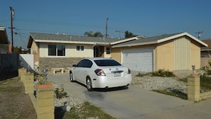A residential house with a garage, a driveway, and a parked car.
