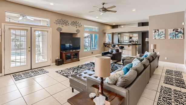 A spacious living room with a large sofa, a television, and a ceiling fan. -  Private Backyard, Golf, Tennis, Spring Training, Wildlife Zoo, Westgate (Litchfield Park)