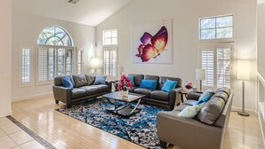 A spacious living room with two sofas, a coffee table, and a large butterfly painting on the wall. -  Private Backyard, Golf, Tennis, Spring Training, Wildlife Zoo, Westgate (Litchfield Park)