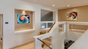 A modern interior with a staircase, two artworks on the walls, and a dining area below. -  Private Backyard, Golf, Tennis, Spring Training, Wildlife Zoo, Westgate (Litchfield Park)