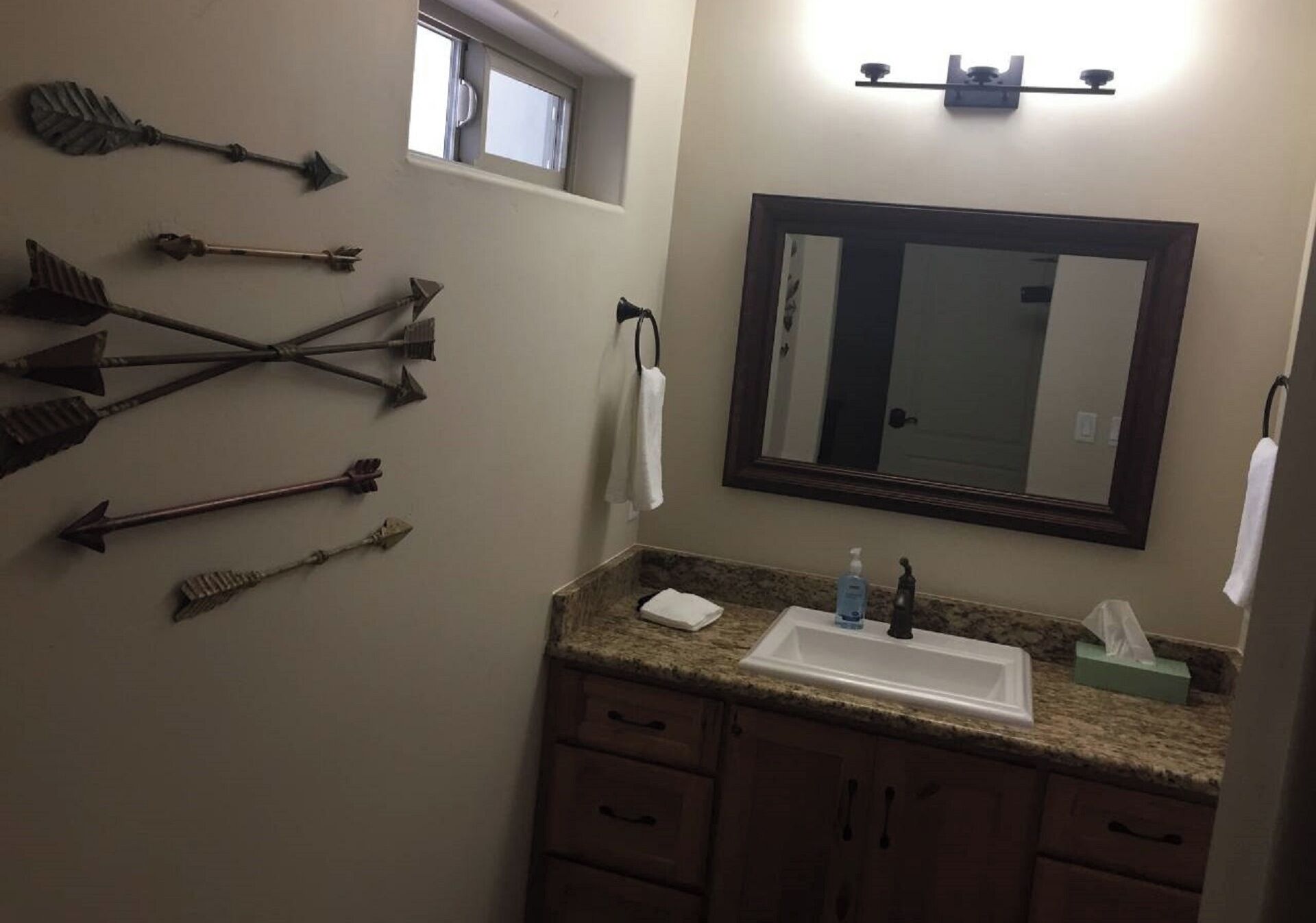 A bathroom with a sink, mirror, and multiple arrows on the wall.