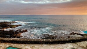 A coastal view with a rocky shoreline and a clear sky.