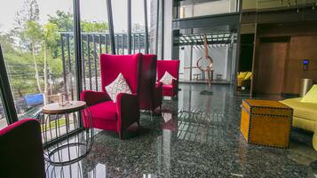Un intérieur moderne avec des fauteuils rouges, un canapé jaune et une petite table en bois.