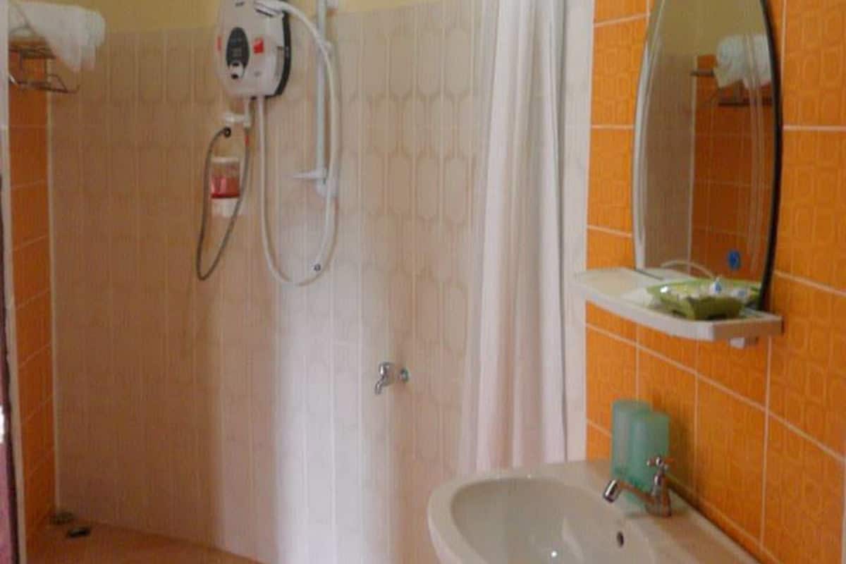 Un baño con ducha, lavamanos y espejo.