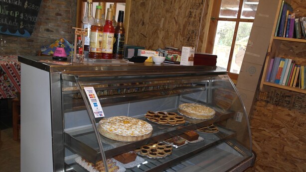 A bakery display case with various baked goods and a selection of beverages. - Cabañas Los Tamarugos (Los Vilos)