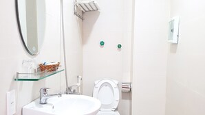 A bathroom with a white sink, a mirror, a toilet, and a shower. - Phu Tai Center Hotel (Quy Nhon Tay)
