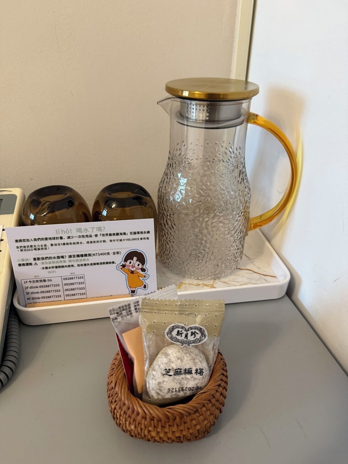 A kitchen counter with a coffee maker, jars, a packet of tea, and a Wi-Fi sign.