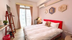 A bedroom with a bed, a nightstand, a red headboard, a window with curtains, and wall art. - Jinguann B&B (Hualien City)