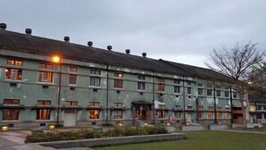 A large, multi-story building with a green facade and multiple windows. - Jinguann B&B (Hualien City)